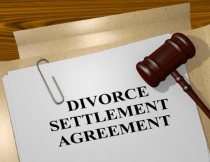 Photo of divorce settlement agreement on a desk with a pen, folders, and judge