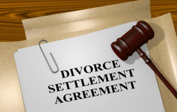Photo of divorce settlement agreement on a desk with a pen, folders, and judge